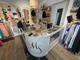 une photo d'une boutique de vêtements avec des vêtements en vitrine