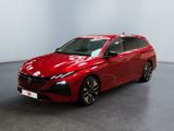 Une voiture rouge est garée dans une pièce aux murs blancs.