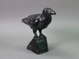statue of a bird on a rock on a gray background
