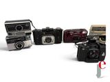 five cameras sitting next to each other on a white surface
