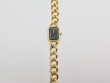 an image of a gold wrist watch with a black face on a white background