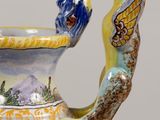a vase with a handle that has a bird on it