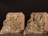 pair of carved wood bookends on a wooden table with a black background