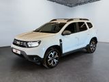 La Dacia blanche est garée dans une grande pièce blanche.