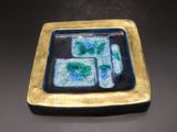 une assiette bleue et verte posée sur une table noire