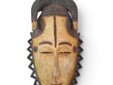 une image d'un masque en bois accroché au mur
