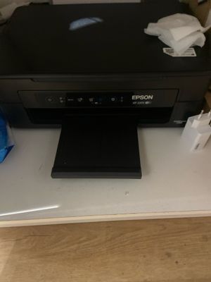 une imprimante posée sur un bureau, avec une souris dessus