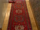 un long tapis rouge posé sur le sol dans un couloir