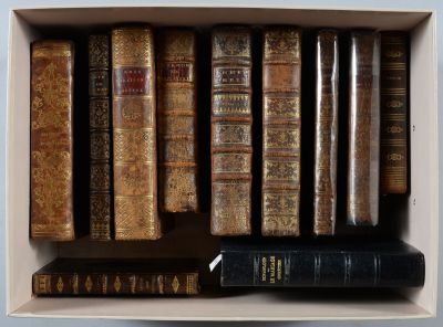 de nombreux livres anciens dans une boîte blanche posée sur une étagère