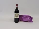une bouteille de vin posée à côté d'un sac violet