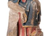 an old statue of a man sitting on top of a rock