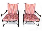 paire de chaises en fer forgé roses et noires avec des coussins rembourrés à rayures
