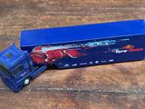un camion miniature posé sur une table en bois
