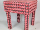 un tabouret fabriqué à partir de canettes de soda sur fond blanc