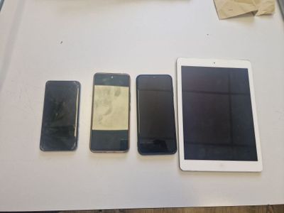 several cell phones are lined up on a table next to a keyboard