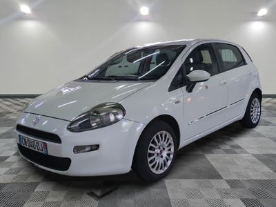 la photo d'une petite voiture blanche garée sur un sol en damier