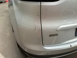 a car that has been dented and is parked in a parking lot