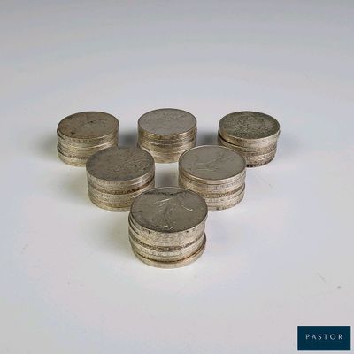 plusieurs piles de pièces d'argent posées sur une surface blanche