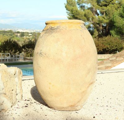 a large vase that is sitting on the ground by the pool