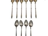 six cuillères en argent et une cuillère à manche, sur fond blanc