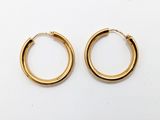 une paire de boucles d'oreilles en or sur fond blanc