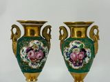 pair of green and gold vases with flowers on them on a white surface