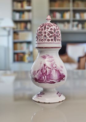 un vase blanc et violet posé sur une table