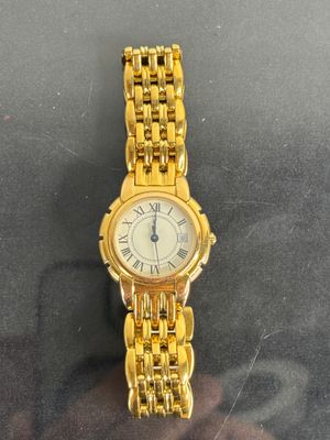 a gold wrist watch with roman numerals on it