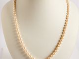 pearl necklace on a mannequin display on a white background