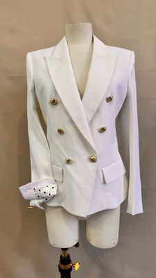 white suit with gold buttons on a mannequin base