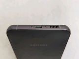 the back of a black samsung phone sitting on top of a white table