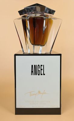 an angel perfume bottle sitting on top of a black stand