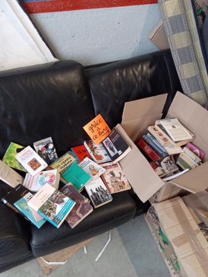 a black leather couch with many books on it
