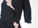 a black dress with pink flowers on the side of it