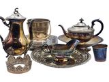 un service à thé en argent posé sur un plateau en argent, avec des tasses et des soucoupes