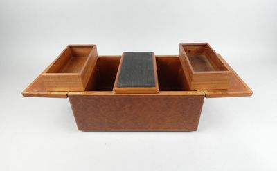 une image représentant une boîte en bois surmontée de trois compartiments