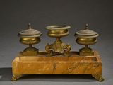 une image représentant une paire de bougies anciennes en laiton posées sur un socle en marbre