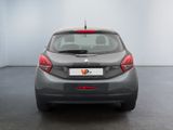 the back of a grey car in a room with a white wall