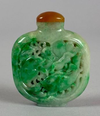 a green glass bottle with a picture of a dragon on it