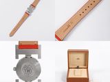 two watches and a watch box on a white surface