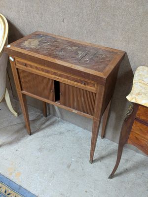 une petite table avec un tiroir, placée à côté d'une chaise