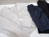 three pairs of men ' s pants sitting on top of a white table