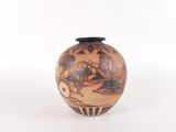 a small vase with a painting on it sitting on a table