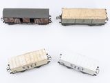 four toy train cars are lined up on a white surface