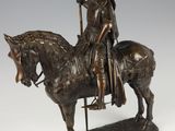 statue of a man on a horse with a flag on a stand