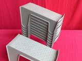 une pile de chaises en plastique posée sur une surface rose