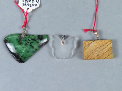 trois morceaux de verre et de bois suspendus à une ficelle rouge
