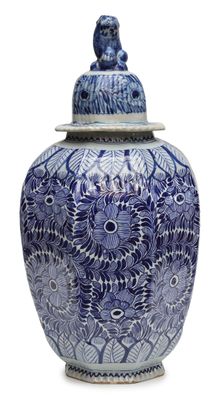 a blue and white vase with a bird on top of it