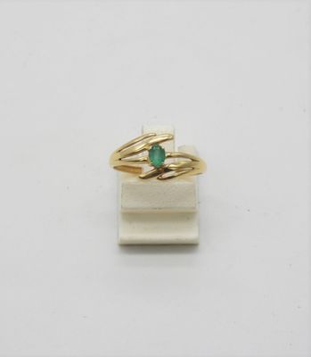 Gros plan sur une bague ornée d'une pierre verte