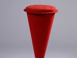Le tabouret rouge est doté d'un piètement en métal et d'une assise rouge.